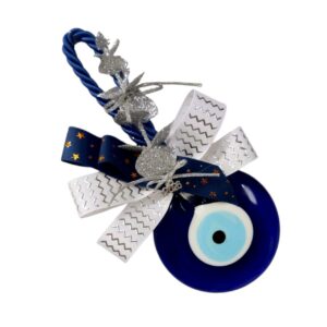 Γούρι 2026 με μπλε γυάλινο μάτι, λευκή κορδέλα και χρυσές λεπτομέρειες.