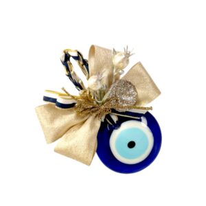 Γούρι 2026 με μπλε γυάλινο μάτι, χρυσό φιόγκο, πέρλες και glitter λεπτομέρειες.