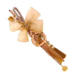 Γούρι 2026 με μεταλλικό ρόδι και σμάλτο, σε μπεζ κορδόνι με σαμπανιζέ φιόγκο και πολυτελή φούντα.