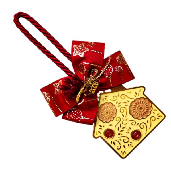 Χειροποίητο γούρι 2026 με μπεζ μεταλλικό σπίτι, κόκκινη κορδέλα και ροζ ανάγλυφα λουλούδια.